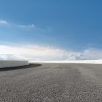 Asphalt road with white barriers under blue sky